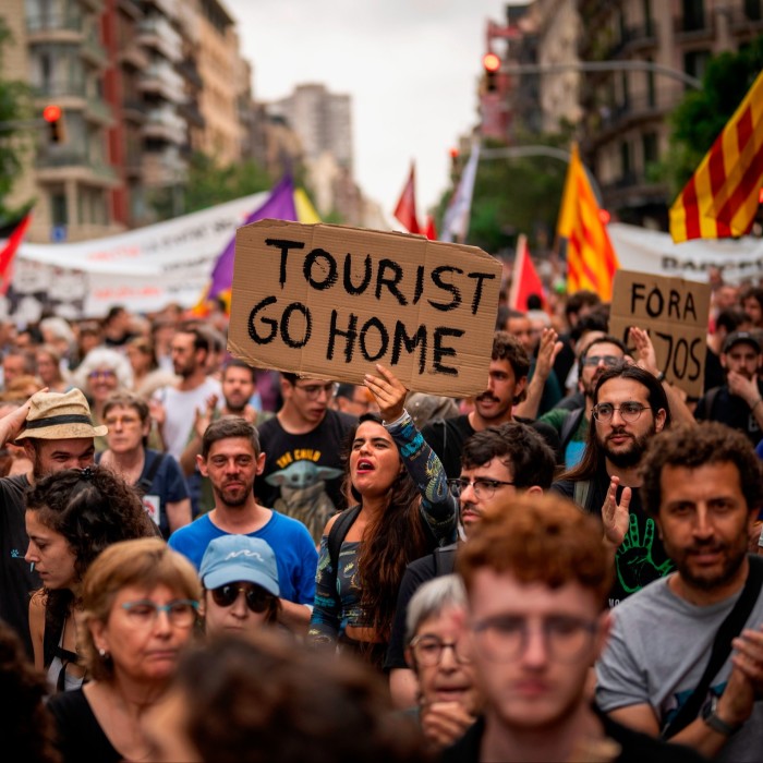 A large protest in a city street with demonstrators holding signs