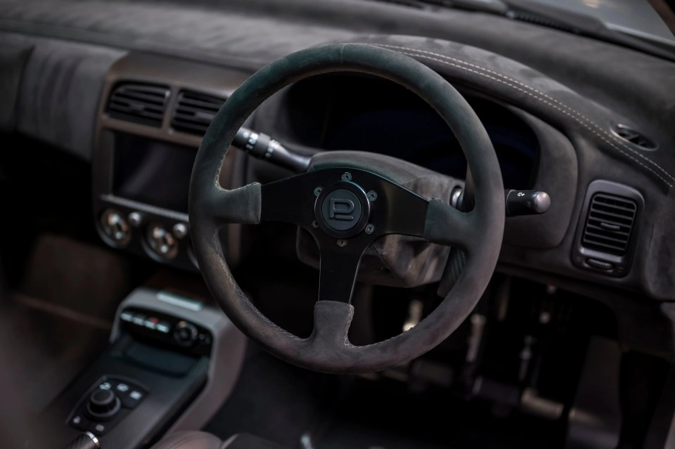 Close-up of a Subaru Prodrive P25's steering wheel and dashboard.