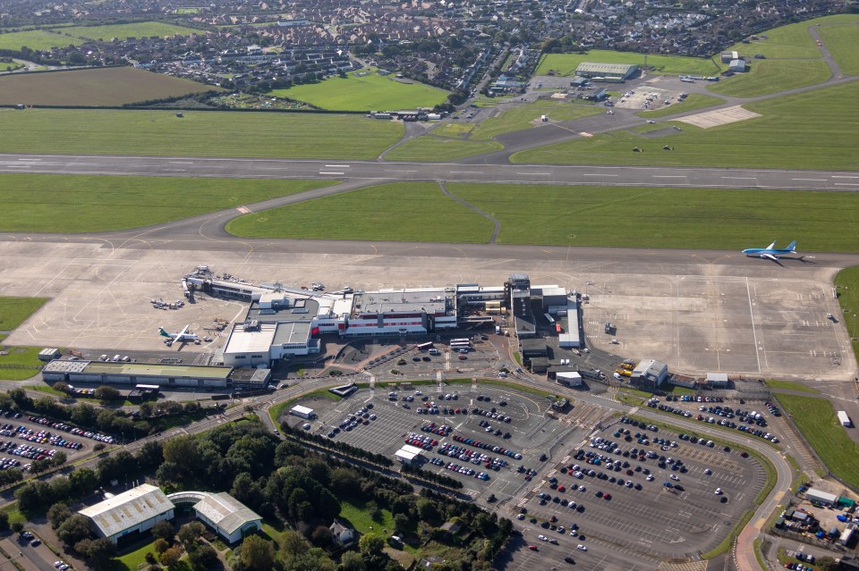 Aerial view of Cardiff Airport terminal building, runways, and parking lots.