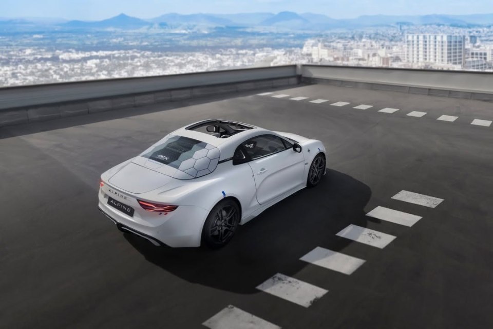 White Alpine sports car on a rooftop.