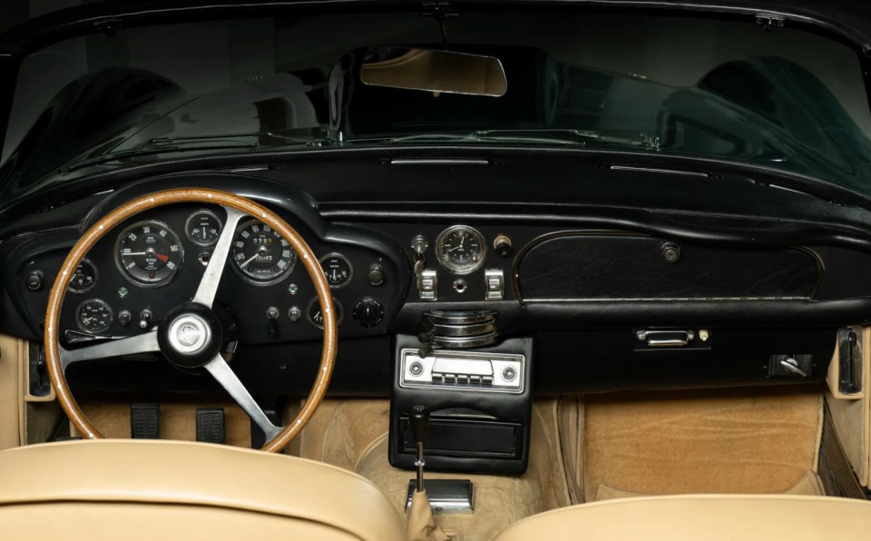 Interior of a dark green Aston Martin DB Short-Chassis Volante with tan leather seats.