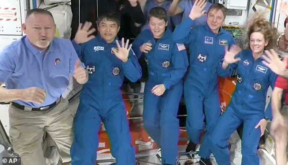 This image made from video by NASA shows astronauts waving after the SpaceX capsule docked with the International Space Station, Sunday, March 16, 2025. Top row from left: Nick Hague, Alexander Gorbunov, Suni Williams, Alexei Ovchinin. Bottom row from left: Butch Wilmore, Takuya Onishi, Anne McClain, Kirill Peskov, Nichole Ayers, Don Pettit and Ivan Vagner. (NASA via AP)