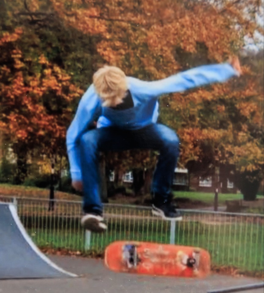 A young man skateboarding in a skate park.