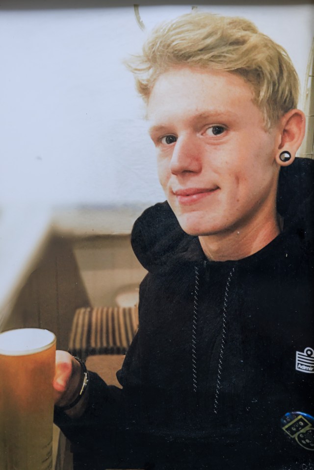 Photo of a young man holding a pint glass.