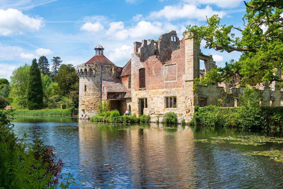 Scotney Castle ruins reflected in a moat.