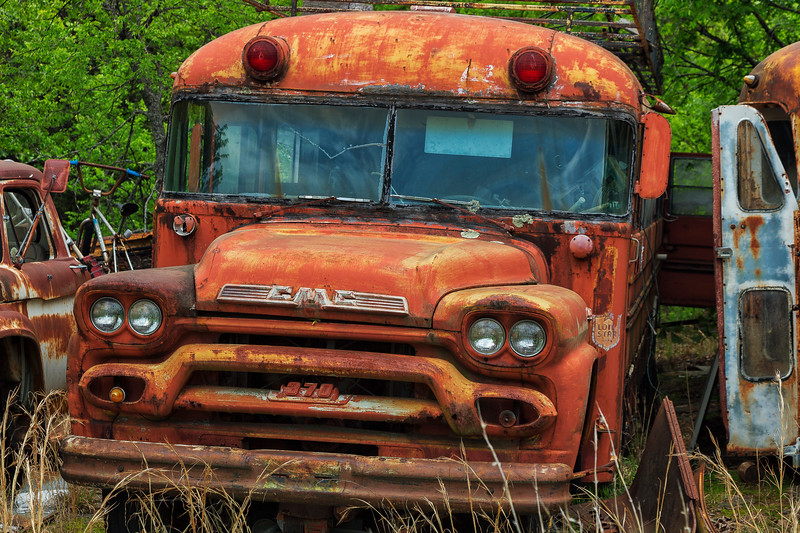 Rusty old school bus in an abandoned graveyard.