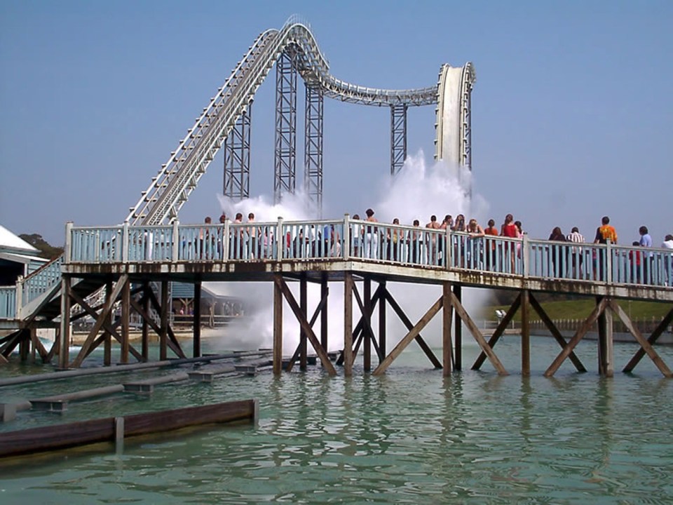 People watching a water ride at a closed theme park.