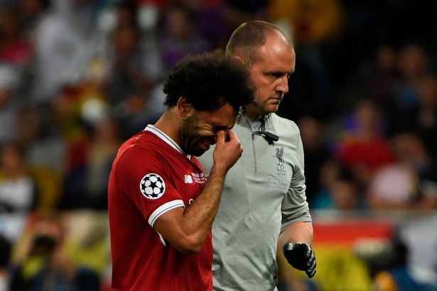 Liverpool's Egyptian forward Mohamed Salah (L) reacts as he is forced the leave the pitch after hurting his shoulder in a challenge with Real Madrid's Spanish defender Sergio Ramos during the UEFA Champions League final football match between Liverpool and Real Madrid at the Olympic Stadium in Kiev, Ukraine on May 26, 2018. (Photo by Paul ELLIS / AFP)        (Photo credit should read PAUL ELLIS/AFP via Getty Images)