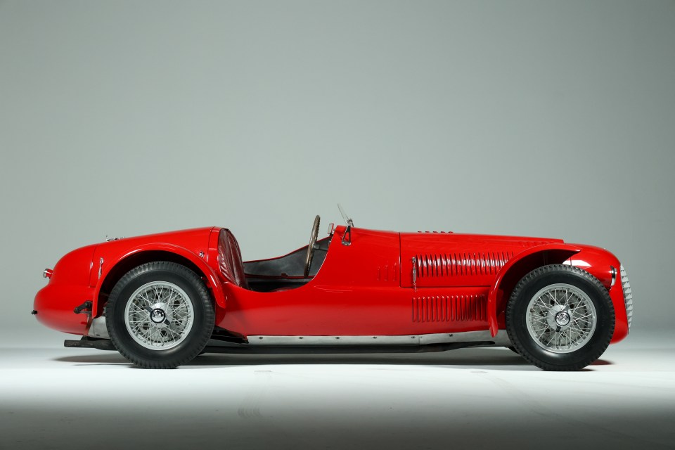 Profile view of a red 1948 Ferrari 166 Spyder Corsa.