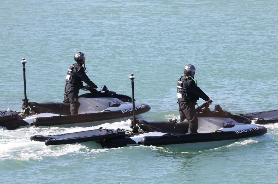 Two Border Force officers on jet skis patrolling the water.