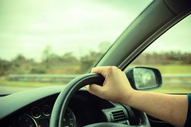 Generic Photo of a man with his hands on the steering wheel