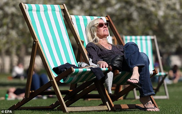 A woman enjoys the warm spring weather in a beach chair Green Park in London, April 4, 2025
