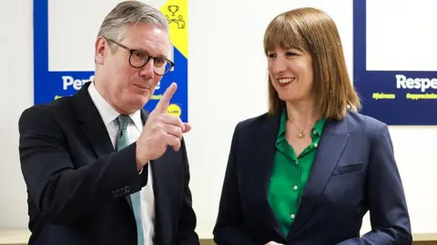 Getty Images A medium close up of Sir Keir Starmer (left) and Rachel Reeves (right) smiling at a visit to a Lidl supermarket in Tottenham Court Road, central London
